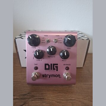 Růžový kytarový efekt s nápisy DIG, dual digital delay a strymon. Na horní straně jsou čtyři otočné ovladače s popisky TIME, REPEATS a MIX, dvěma řad…