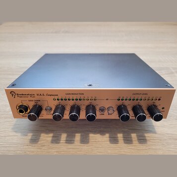 Stříbrný rackový kompresor s nápisem FredenStein V.A.S. Compressor Professional Audio a logem ve tvaru stylizedovaného písmena F. Přední panel obsahu…