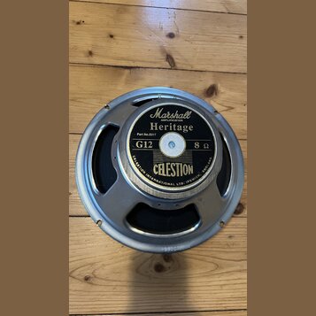 Kruhové reproduktory s kovovým rámem a černou membránou. Na středovém štítku jsou nápisy Marshall AMPLIFICATION, Heritage, Part No.S311f, G12 a 8 Ω.…