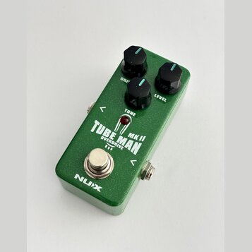 Zelený kytarový efekt s nápisem TUBE MAN MK II OVERDRIVE. Na horní straně jsou tři černé otočné ovířky s popisky DRIVE, TONE a LEVEL. V dolní části j…