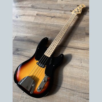 Elektrická basová kytara s tělem v přechodové barvě od žluté po černou a černým pickguardem. Na hlavě hnedku je viditelné logo "Fender". Nástroj má s…