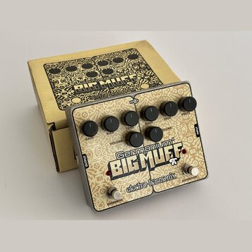 Kytarový efekt v kovovém šasi s béžovým povrchem a ozdobným vzorem. Na pedálu je nápis „Germanium 4 BIG MUFF“ a logo „electro-harmonix“. Jsou zde ovl…