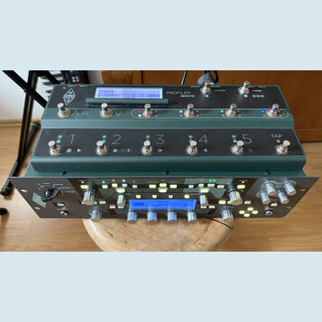 Zelený pedalboard s nápisem PROFILER REMOTE a logem KEMPER. Obsahuje několik stoupacích spínačů s číslováním 1 až 5 a tlačítkem TAP, nad kterými jsou…