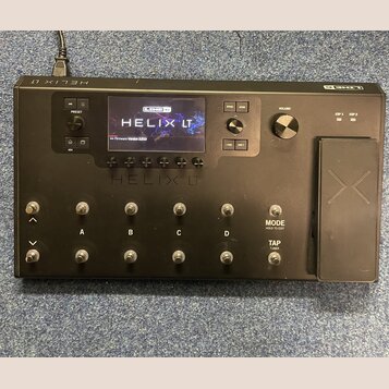 Černý kytarový procesor Line 6 Helix LT s displejem, na kterém je nápis LINE 6 HELIX LT a Firmware Version 3.60.0. Na přední straně jsou viditelné ná…