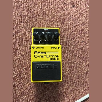 Žlutý kytarový efekt Boss Bass OverDrive ODB-3. Na horní straně jsou čtyři černé ovládací knoflíky s popisky MIN MAX, CUT BOOST (s přepínačem HIGH LO…