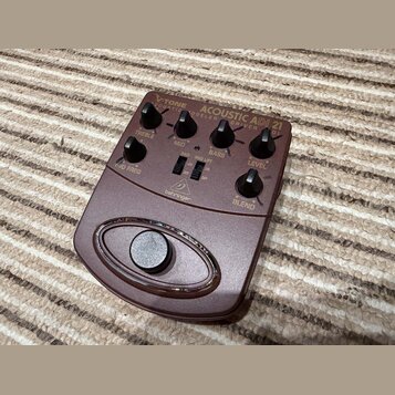 Hnědý kytarový pedál s nápisy V-TONE ACOUSTIC ADI 21 a COURTIC MODELER DRIVER DI. Na horní části jsou umístěny čtyři otočné knoflíky s popisky TREBLE…