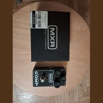 Černý kytarový efekt pedál s nápisem Super COMP a logem MXR. Na horní straně jsou tři ovládací knoflíky s popisky OUTPUT, ATTACK a SENSITIVITY. Vedle…