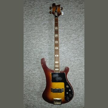 Elektrická kytara s tělem v barvě sunburst a hnědým hnedkem. Na hlavě je bílý nápis jolana a vedle něj menší text 3-55. Kytara má černý pickguard, dv…