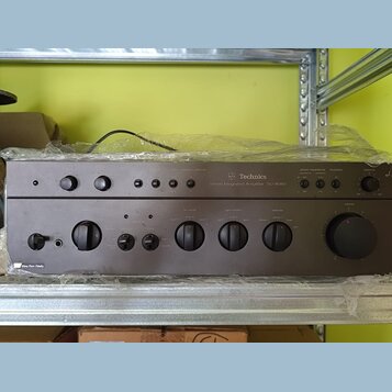 Šedý stereo zesilovač s nápisem Technics Stereo Integrated Amplifier SU-8080. Přední panel obsahuje několik otočných ovladačů, tlačítek a přepínačů s…