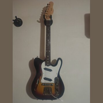 Elektrická kytara s tónem sunburst a bílým pickguardem. Na hlavě hředu je nápis IRIS a na spodní části těla nápis JOLANA. Nástroj je vybaven třemi sn…