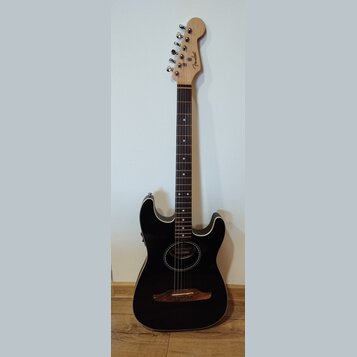 Černá akustická kytara s vyvedeným bílým okrajem těla a přírodním dřevěným hmatníkem. Na hlavě je viditelné logo Fender a na těle v oblasti otvoru je…