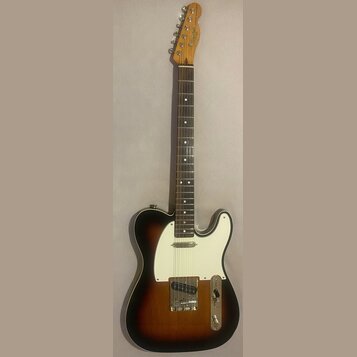 Elektrická kytara s tónem sunburst a bílým pickguardem. Na hlavě hředu je viditelné logo Squier by Fender a nápis CUSTOM TELECASTER. Nástroj je v dob…