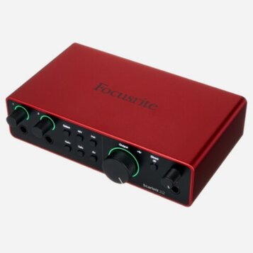 Červený audio rozhraní s kovovým povrchem. Na horní straně je nápis Focusrite a na předním panelu vpravo označení Scarlett 2i2. Zařízení má dva vstup…