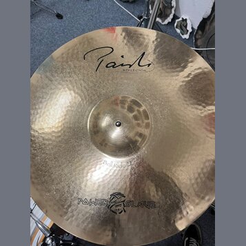 Kladivovaná mosazná činely s nápisem Paiste a pod ním menším REFLECTOR. Ve spodní části je uveden model Bell Ride 22" a logo POWER SLAVE s motivem le…