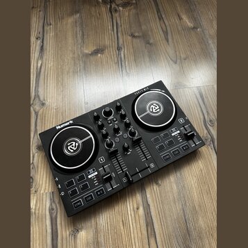 Černý DJ 컨트롤러 značky Numark s nápisem PARTY MIX. Zařízení obsahuje dva stříbrné jog-wheels, několik otočných knoflíků a posuvníky. Povrch je v dobrém…