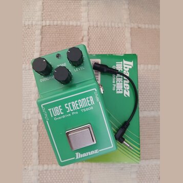 Zelený kytarový efekt s nápisy TUBE SCREAMER, Overdrive Pro TS808 a logem Ibanez. Na horní straně jsou tři černé ovládací knoflíky s popisky OVERDRIV…