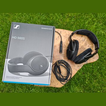 Na fotografii jsou černá sluchátka s velkými náušníky a přiložená krabice. Na krabici je nápis SENNHEISER, model HD 560S a text Reference-grade headp…