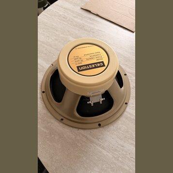 Bežový reproduktor s černou membránou. Na zadní straně je žlutý štítek s nápisy: CELESTION, Model G12 H, Power capacity 75 watts, Impedance 16 ohms,…