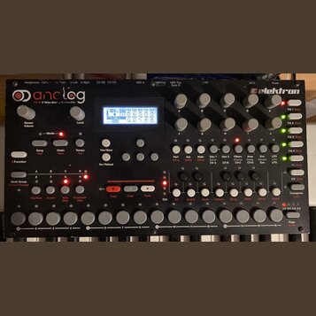 Černý analogový syntetizátor s bílými klávesami. Na horním panelu jsou nápisy analog a elektron, displej s modrým podsvícením a řada šedých otočných…