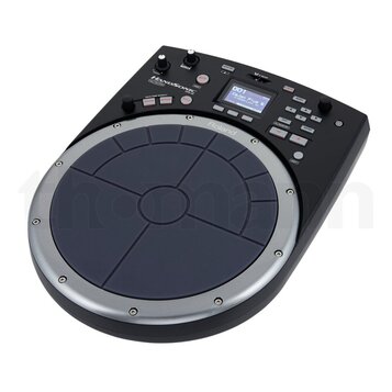 Elektronický perkusní pad černé barvy s modrým gumovým playing polem rozděleným na zóny. Na přístroji jsou viditelné nápisy HANDSONIC, HP-20 a Roland…