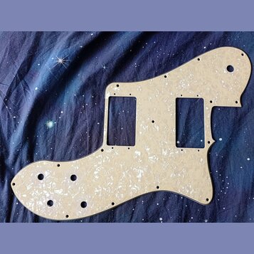 Bílá pickguard s perleťovým efektem pro elektrickou kytaru. Má dva obdélníkové výřezy pro snímače a několik kulatých otvorů na šrouby a ovládací prvk…