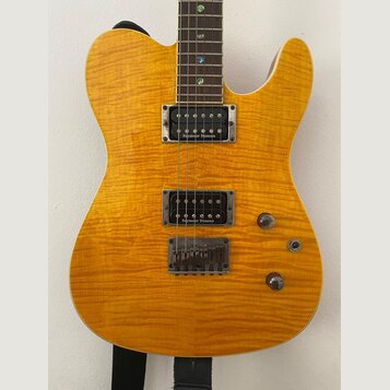 Elektrická kytara s žlutým plamenovitým povrchem těla. Na obou humbuckerech je nápis Seymour Duncan. Kytara má tři ovládací knofíky a strunoměr s fix…