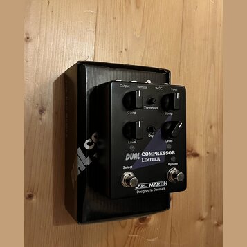 Černý kytarový pedál s nápisem DUAL COMPRESSOR LIMITER a značkou CARL MARTIN Designed In Denmark. Zařízení má čtyři otočné oválné knoflíky s popisky…