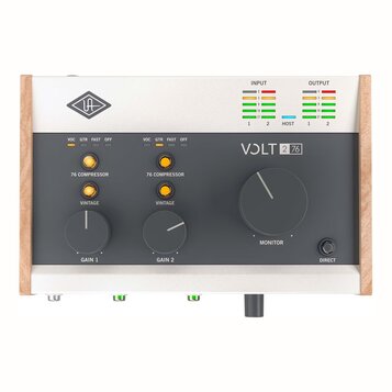 Audio rozhraní s bílým šasi a dřevěnými bočními panely. Na čelní straně je tmavý panel s nápisy VOLT 2 76, UA a ovládacími prvky Gain 1, Gain 2 a Mon…