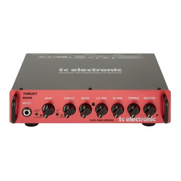 Červený basový zesilovač s šedým horním krytem. Na předním panelu jsou nápisy THRUST BQ500, INPUT a ovládací knofíky GAIN, THRUST, BASS, LO-MID, HI-M…
