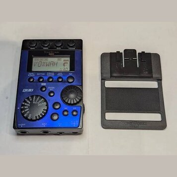 Modrý kytarový efekt s displejem, na kterém je nápis VOXWAH. Na horní části je značka ToneWorks a model X-Bass, vlevo nápis BEMS. Zařízení obsahuje n…