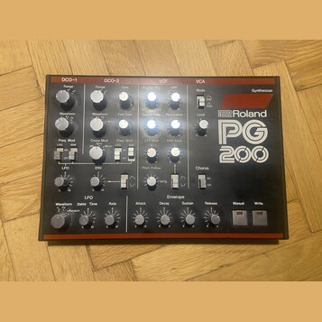 Černý analogový syntetizátor s červeným rámem a bílými nápisy. Na pravé straně je výrazné logo Roland a modelové označení PG 200. Přístroj obsahuje ř…