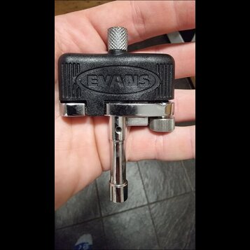 Černý plastový klamp s chromovaným kovovým mechanismem. Na horní části je vyražen nápis EVANS v oválném rámu. Nástroj vykazuje mírné známky používání…