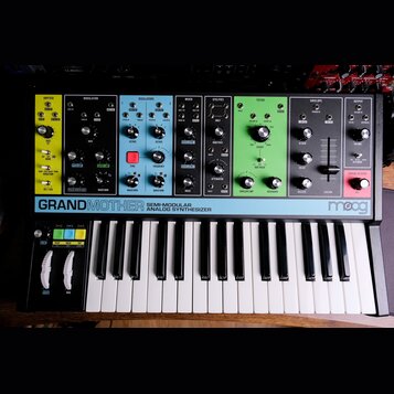 Černý semi-modulární analogový syntetizátor s klaviaturaí, který má v horní části barevně rozdělené sekce: žlutou (ARP/SEQ), černou (MODULATION), mod…
