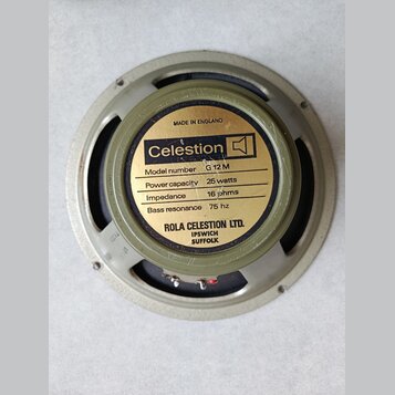 Zadní strana reproduktoru s kovovým rámem a magnetem. Na zlaté štítku je uveden nápis Celestion s logem, Model number G 12 M, Power capacity 25 watts…