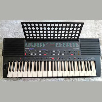 Černý elektronický klavír s nápisem YAMAHA PSR-400 a označením AWM. Nástroj má standardní klávesnici s bílými a černými klávesami, v levém dolním roh…