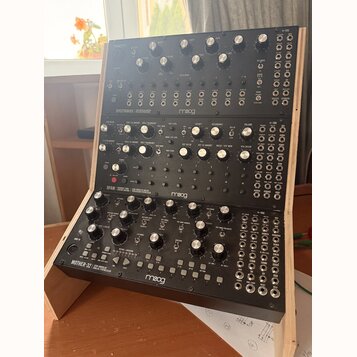 Tři černé modulační syntetizátory značky moog umístěné v dřevěném stojanu. Horní jednotka nese nápis SPECTRAVOX SEMI MODULAR SYNTHESIZER, prostřední…