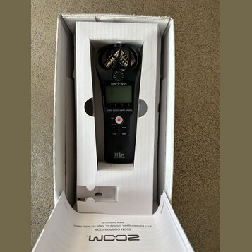 Černý digitální nahrávač Zoom H1n Handy Recorder v bílém originálním packagingu. Na přístroji je vidět displej, červené tlačítko REC a ovládací prvky…