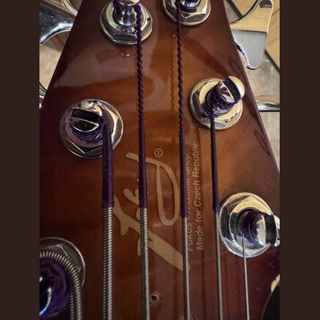 Detail zadní strany hředu kytary v hnědé barvě s kovovými ladicími mechanismy. Na povrchu je vidět zlaté logo a nápisy „Fokus Guitar Shop“ a „Made fo…