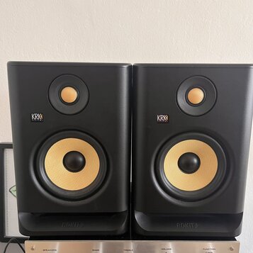 Dva černé studiové monitory značky KRK SYSTEMS. Oba mají žlutý basový reproduktor a menší výškovek v horní části. V dolní části je u obou zařízení ná…