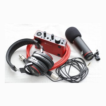 Sada červeného a černého audio vybavení na světlém podkladu. Obsahuje červený zvukový interface s nápisem Focusrite, černý mikrofon s popsem a nápise…