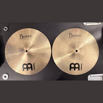 Dvě mosazné činely s viditelným broušením a hloubkovým rýhováním. Oba mají nápisy Byzance a logo MEINL. Na levém číneli je text 13" Medium Hihat, Bot…