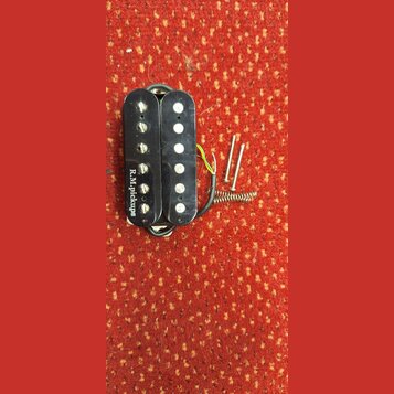Černý humbucker s dvěma řadami šesti bílých pólů. Na levé straně je nápis R.M.pickups. K snímači vedou elektrické vodiče a vedle něj jsou položeny dv…