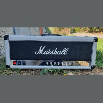 Kytarový kombo zesilovač v šedém vinylovém potahu s černou mřížkou, na které je bílý nápis Marshall. Spodní ovládací panel obsahuje červený vypínač,…